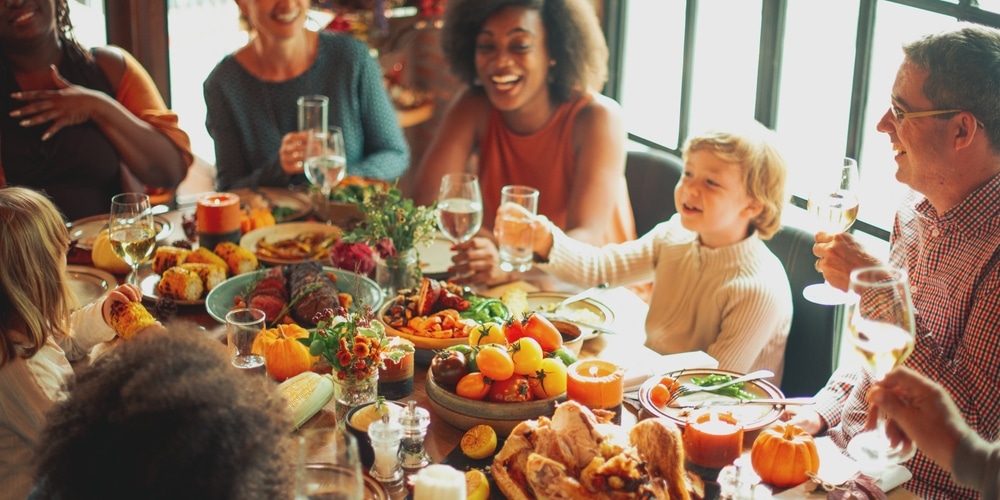 Diverse group enjoying a festive meal. Laughter and joy around a table filled with food. Celebration with friends and family, sharing a joyful meal. Celebrations and family gathering.