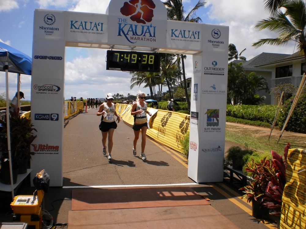 Kauai, Hawaii, Oct 9, 2010. Runners approach the finish line at The Kauai Marathon, a popular annual race event in Hawaii. The setup features sponsors, timing clock, and tropical island backdrop.