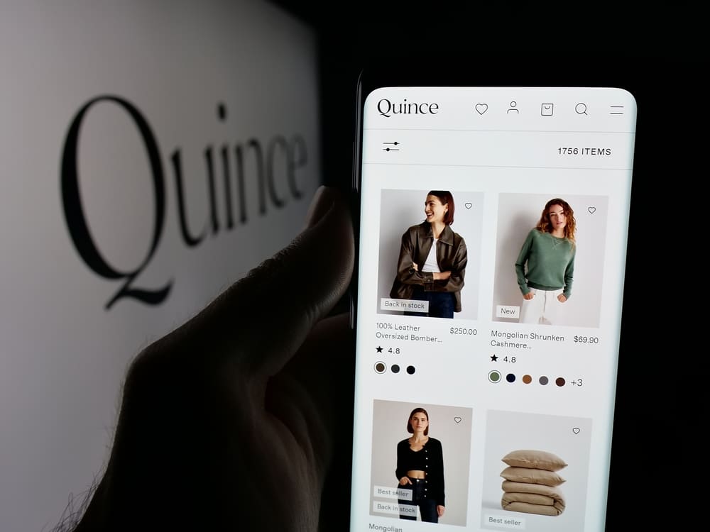 Stuttgart, Germany - 10-20-2025: Person holding smartphone with web page of US fashion company Last Brand Inc. (Quince) on screen in front of logo. Focus on center of phone display. Unmodified photo.