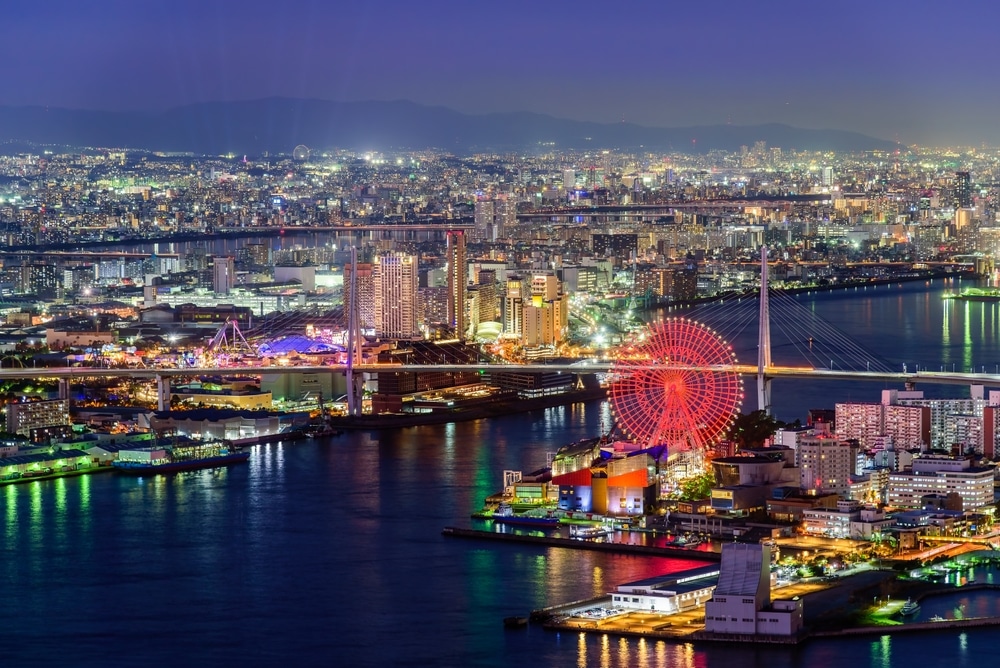 Aerial twilight view of Osaka city at Osaka bay area with the ferris wheel. Japan architecture landscape background.