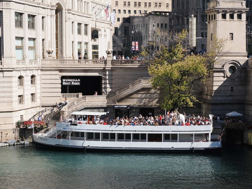 Chicago, IL - September 18, 2025: The 'Lucia' tour boat docked on the Chicago River, with historic architecture and Riverwalk steps in the background.