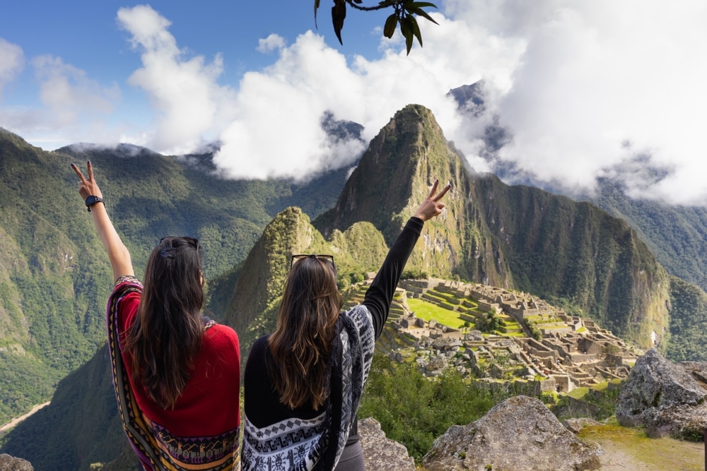 women in typical Peruvian ponchos celebrating their visit to machu picchu