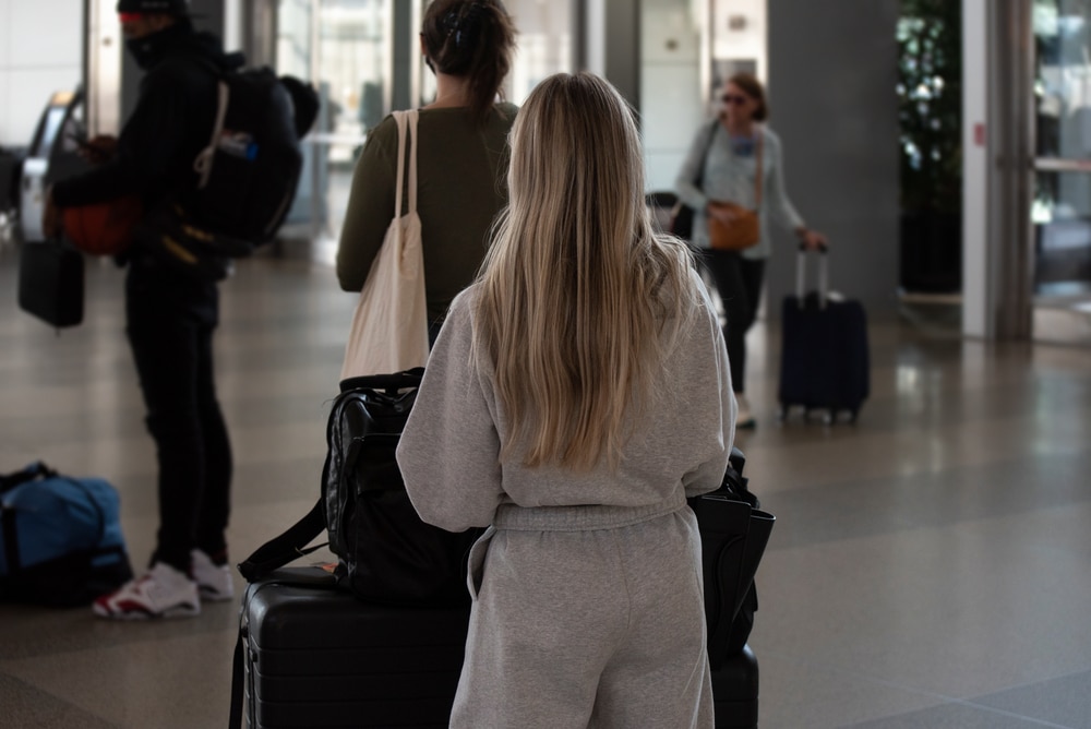 Morrisville, NC - United States- 05-27-2021: A young, blonde woman stands in line at the airport.