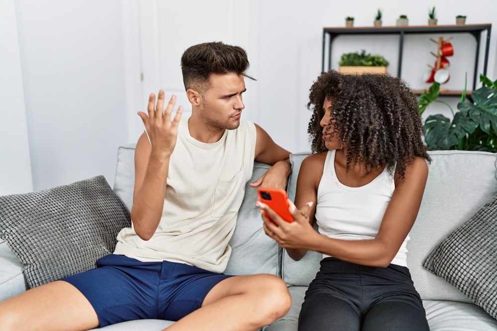 Man and woman couple with problems using smartphone at home