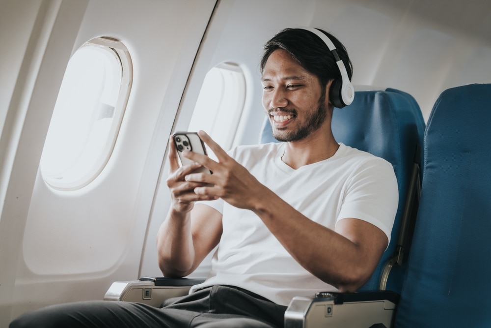 Asian male tourist enjoying airplane travel, traveling around the world on his own.