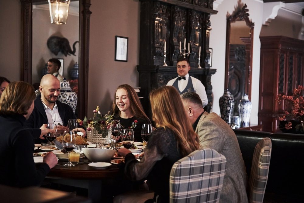 This is professional service. Family friends having nice time in beautiful luxury modern restaurant.