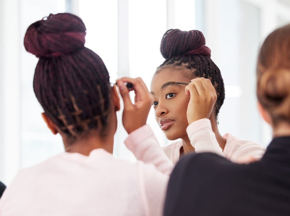 Ballerina, studio and women with makeup by mirror for recital, cosmetics and preparing for performance. Ballet, academy and people with beauty product in reflection for theater, dance and mascara
