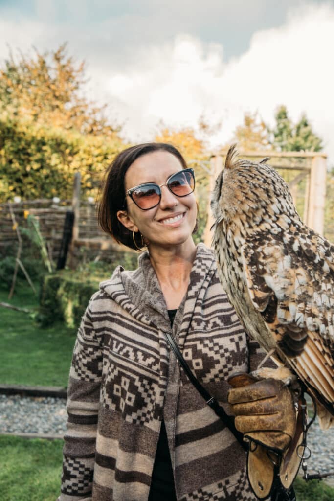 Lindsey holding an owl wearing a merino wool cardigan in Ireland