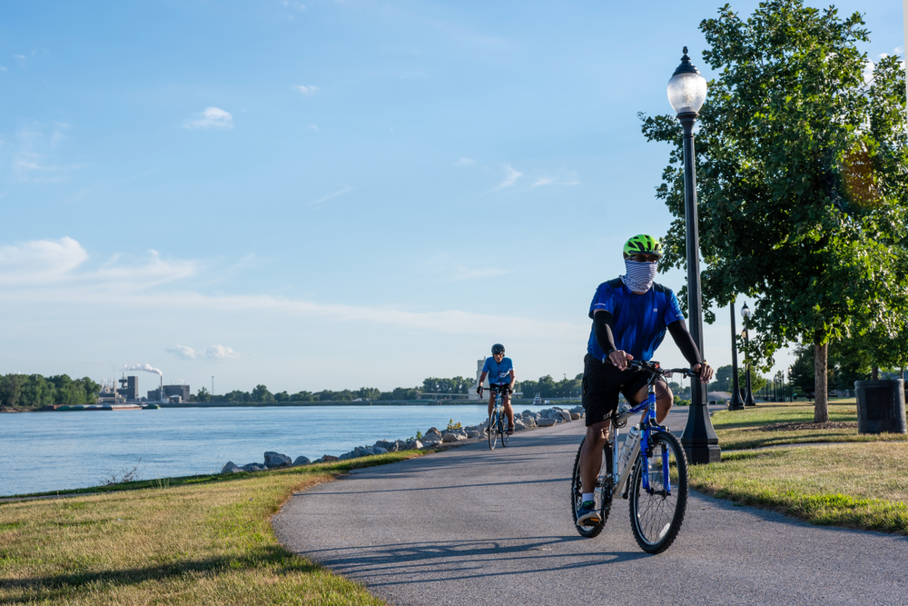 Muscatine, Iowa/USA-July 17, 2018: Two men getting exercise by riding bikes on a bike trail along the Mississippi River waterfront in downtown Muscatine during early evening.