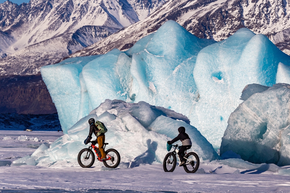 Two teenagers fat biking on Knik Glacier north of Anchorage, Alaska, USA