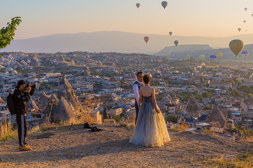 GOREME, TURKEY - JULY 20, 2019: Sunrise wedding shooting above Goreme town in Cappadocia, Turkey