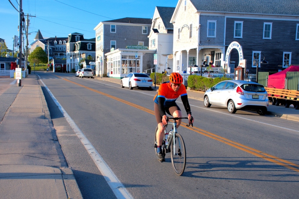 New Shoreham, Rhode Island USA May 22, 2024: Bicyclist takes an early morning ride past the harbor side shops.