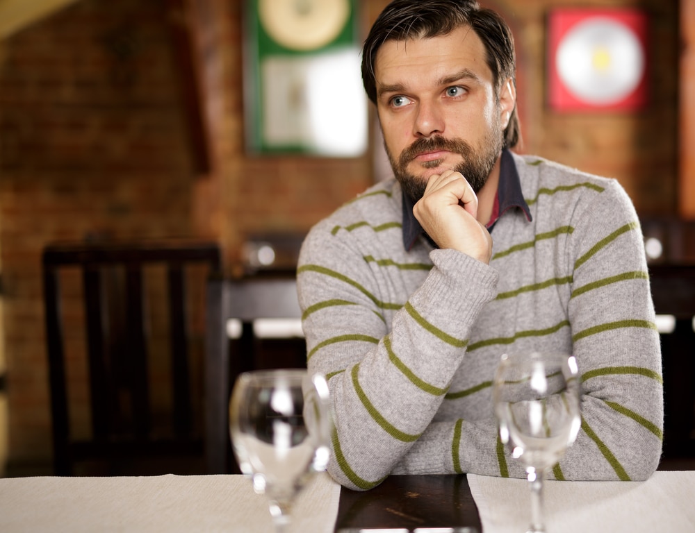 Young handsome man sitting in a restaurant and looking away