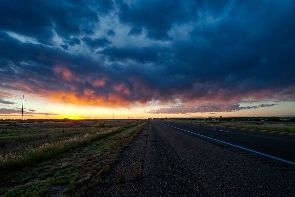 Vibrant sunset illuminates empty interstate highway in rural Texas panhandle USA