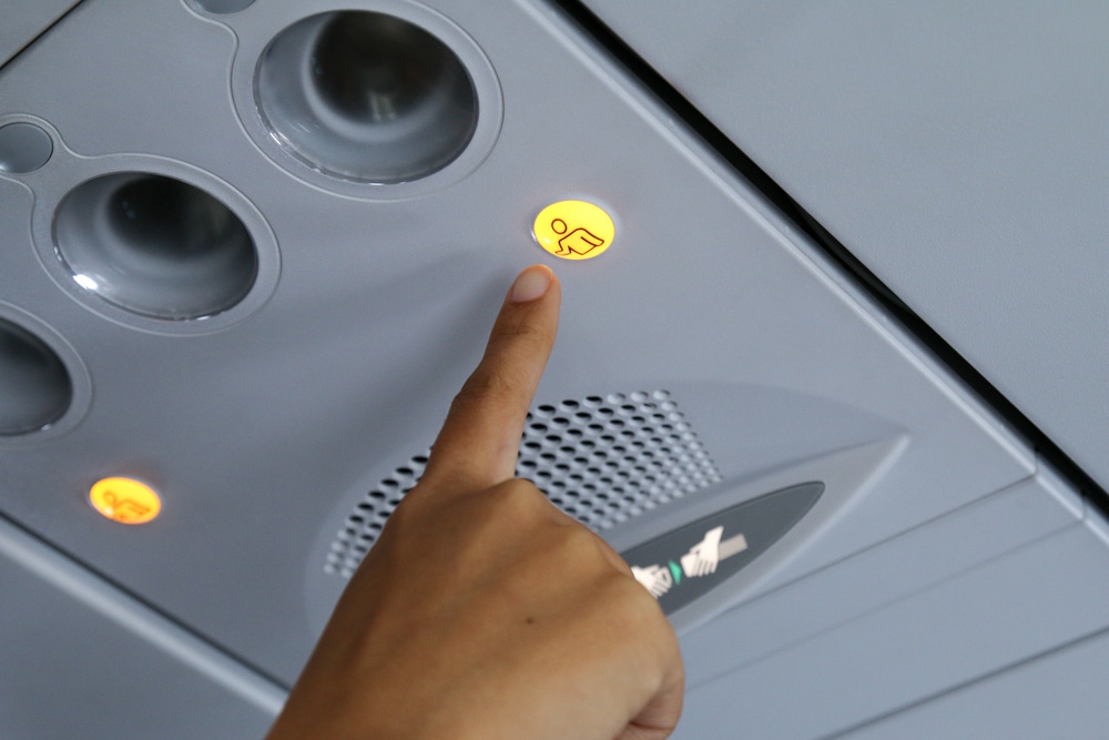 Hand pressing flight attendant call button