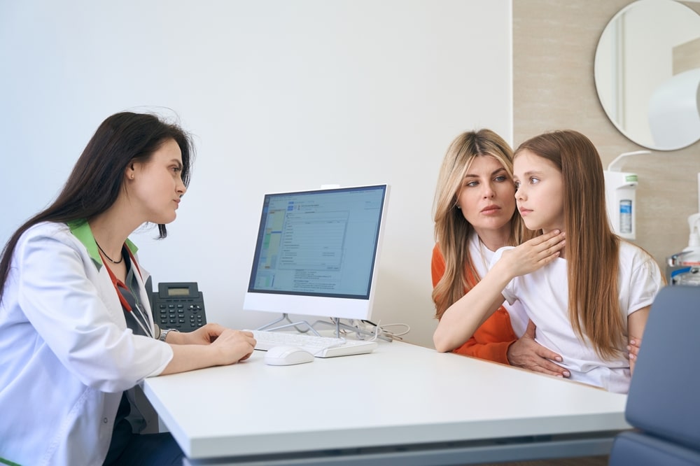 Little girl patient complaining of sore throat and trouble swallowing