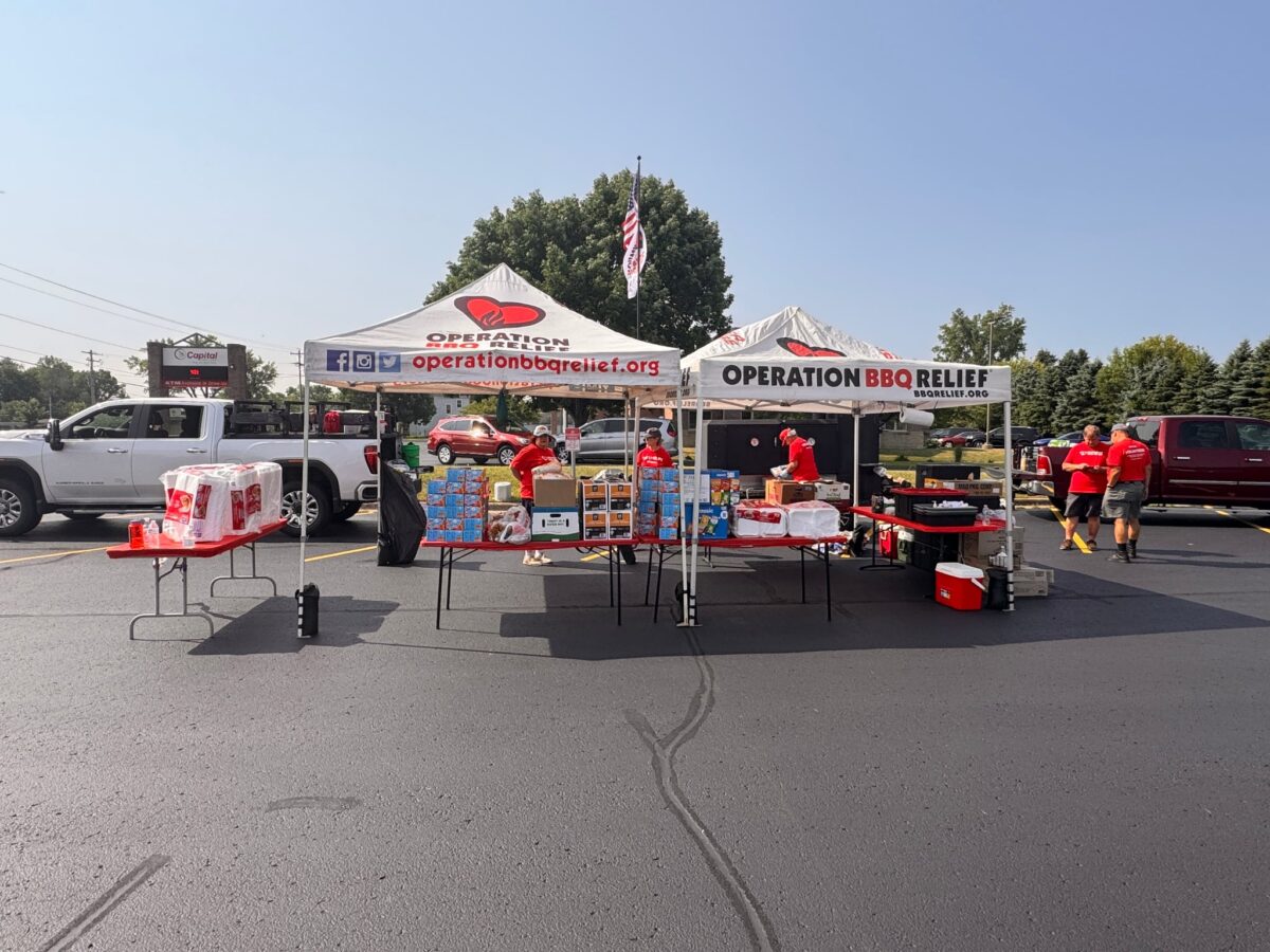 Operation BBQ Relief volunteers prepare meals in the St. Vincent de Paul parking lot in Oshkosh for first responders, recovery crews and families affected by the Appleton-Menasha tornado.