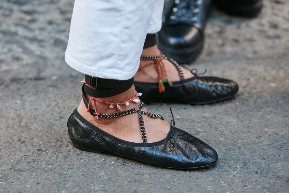 MILAN - JANUARY 16: Woman with black ballerinas shoes with chains and anklet before N 21 fashion show, Milan Fashion Week street style on January 16, 2017 in Milan.