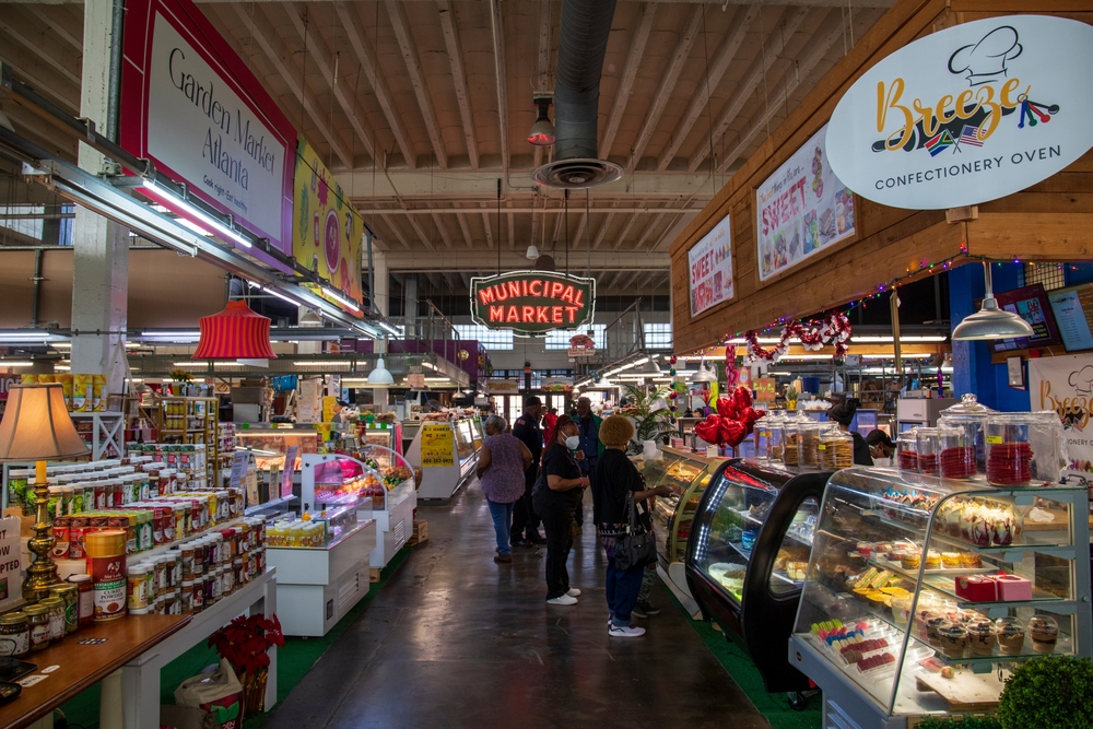 Atlanta, Georgia USA - 2 18 2023: Inside Municipal Market with a red neon sign and colorful products along an aisle filled with African American people shopping in Atlanta Georgia USA